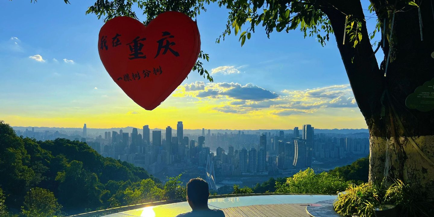Sunset over the Chongqing skyline from the One Tree Viewing Platform on Nanshan, with its red heart-shaped sign